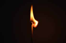 a matchstick is lit in darkness